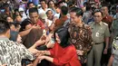 Presiden RI Joko Widodo beserta ibu Iriana disambut warga di sekitar Lapangan Bedeng, Pisangan Baru, Jakarta, Selasa (8/9/2015). Kedatangan Presiden Jokowi untuk memberikan sejumlah paket sembako dan buku kepada warga. (Liputan6.com/Helmi Fithriansyah)