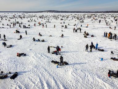 Pemancing di dekat lubang pemancingan saat Brainerd Jaycees Ice Fishing Extravaganza tahunan ke-32 di Gull Lake's Hole di Teluk Day, Minnesota pada 29 Januari 2022. Hampir 10.000 pemancing dari Minnesota dan negara bagian lain menghadiri kontes memancing es amal terbesar di dunia. (Kerem Yucel/AFP)