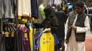 Seorang wanita memegang kaus Cristiano Ronaldo di toko klub Al Nassr di Riyadh, Arab Saudi, Senin, 2 Januari 2023. Antusiasme suporter berburu jersey sang megabintang dari Portugal itu membuat pemasukan tim bertambah. (AP Photo/Amr Nabil)