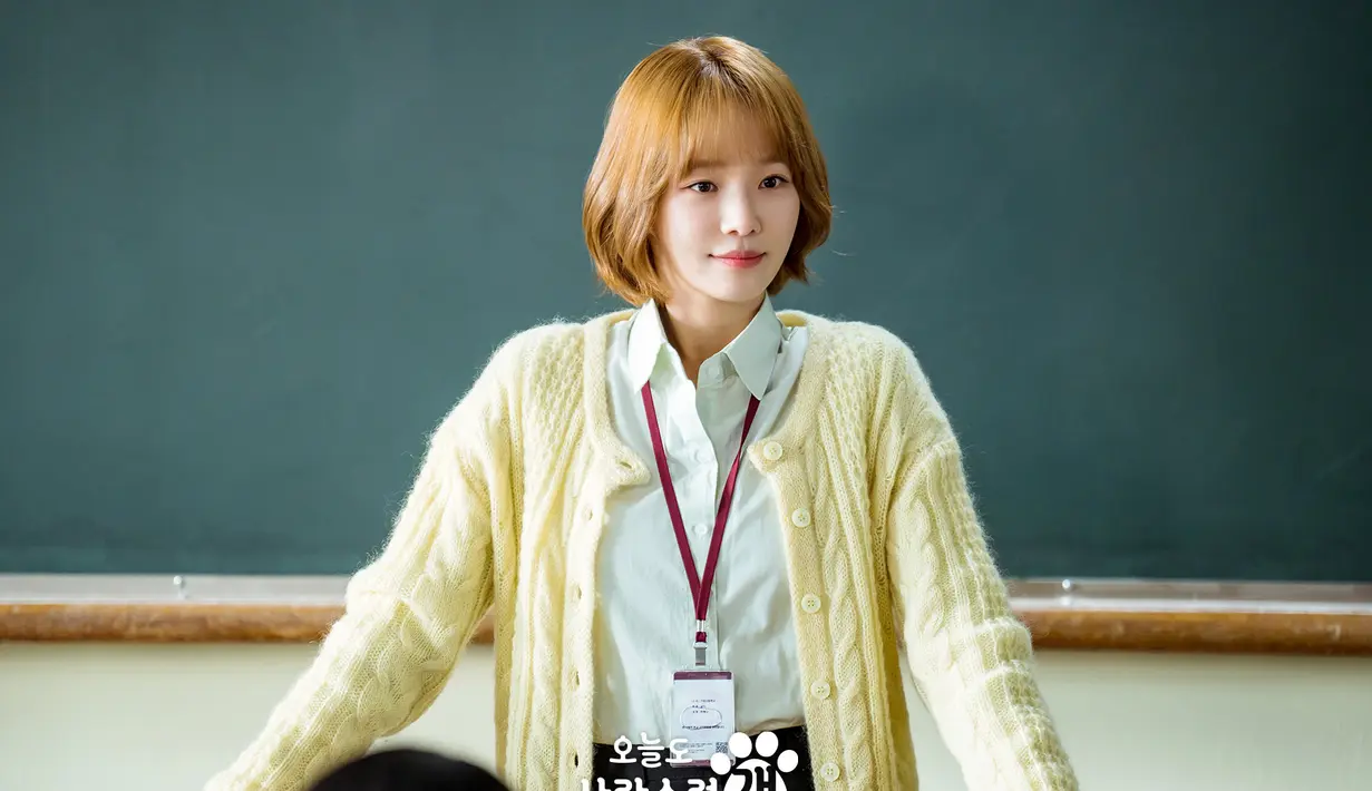 Saat berdiri di depan papan tulis dan menatap murid-muridnya dengan penuh kasih sayang, senyuman lembut Han Hae Na mencerahkan kelas. (Foto: MBC via Soompi)