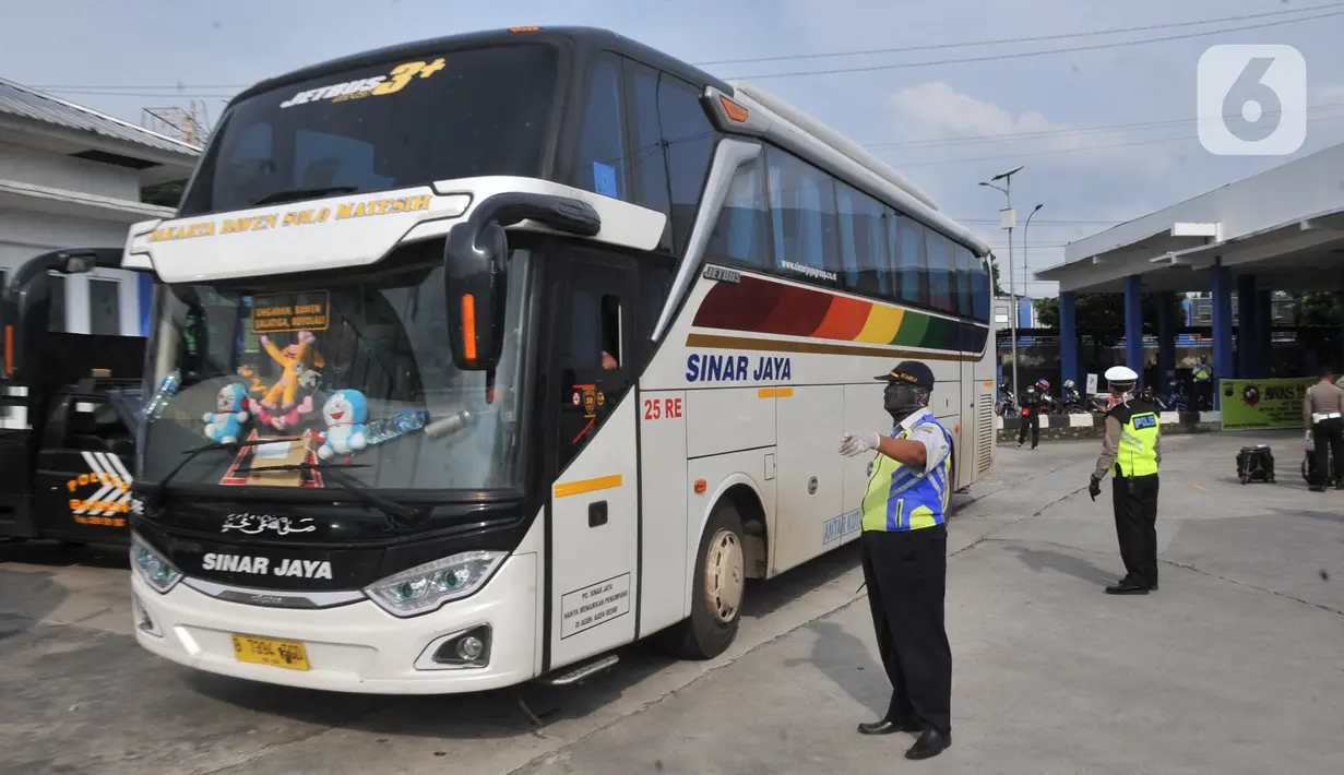 Petugas Direktorat Lalu Lintas Polda Jawa Tengah saat menggelar sterilisasi puluhan angkutan bus yang masuk di Terminal Bawen, Jumat (27/3/2020).  Sterilisasi dilakukan dengan menyemprotkan cairan disinfektan ke armada dan para penumpang yang turun di terminal tersebut. (Liputan6.com/Gholib)