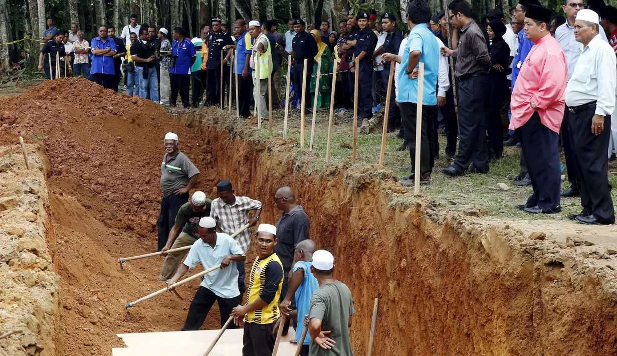 Warga membantu proses pemakaman massal jenazah yang di duga etnis Rohingya di Alor Setar, Malaysia, Senin (22/6/2015).  21 dari 106 jenazah tak dikenal yang ditemukan bulan lalu dimakamkan hari ini. (Reuters/Olivia Harris)