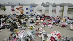 Aktivis lingkungan mengenakan pakaian yang terbuat dari sampah plastik berbaring di tanah selama kampanye untuk memperingati Hari Bumi melawan perubahan iklim di Seoul, Korea Selatan, Jumat (22/4/2022). (AP Photo/Ahn Young-joon)