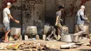 Orang-orang memasak dengan kayu bakar, di tengah kelangkaan bahan bakar dan gas, untuk menyediakan makanan bagi para pengungsi Palestina di tengah serangan Israel di Khan Yunis, di Jalur Gaza selatan pada 15 Oktober 2023. (MAHMUD HAMS / AFP)