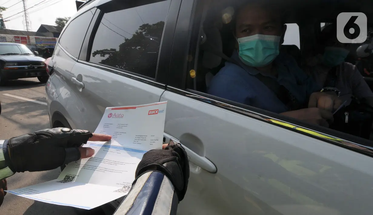 Petugas memeriksa surat Tes Rapid Antigen pengendara di check point penyekatan arus mudik di kawasan Pasar Mudik, Bogor, Jumat (7/5/2021). Penyekatan pemudik pada jalur alternatif Parung diberlakukan jelang Lebaran guna mengantisipasi risiko peningkatan kasus COVID-19. (merdeka.com/Arie Basuki)