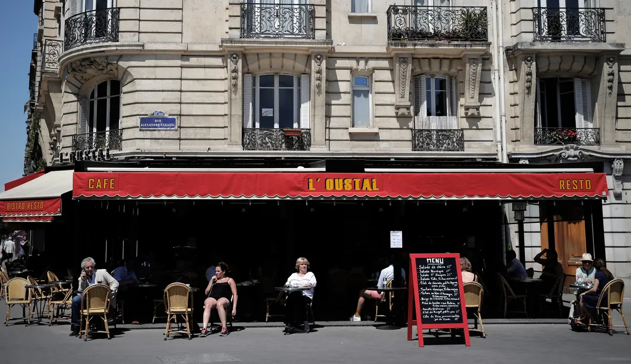 Orang-orang duduk di teras kafe di Paris, Selasa (2/6/2020). Warga Paris terkurung selama berbulan-bulan karena lockdown Corona namun, kini sebagian kafe dan restoran di kota itu dibuka kembali usai pelonggaran pembatasan. (AP Photo/Christophe Ena)