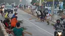 Warga berebut uang yang dilemparkan pengguna jalan menggunakan sapu di Jembatan Sewo, Indramayu, Jawa Barat, Senin (3/6/2019). Kehadiran pencari sedekah tersebut biasanya kian bertambah banyak saat menjelang arus mudik Lebaran. (Liputan6.com/Herman Zakharia)