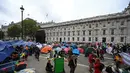 Para aktivis iklim duduk dalam tenda saat mereka berkemah di Westminster, London, Inggris, Selasa (8/10/2019). Pemberontakan Kepunahan adalah bagian dari upaya para aktivis dalam mendorong para pemimpin global untuk serius merespons perubahan iklim. (Ben STANSALL/AFP)