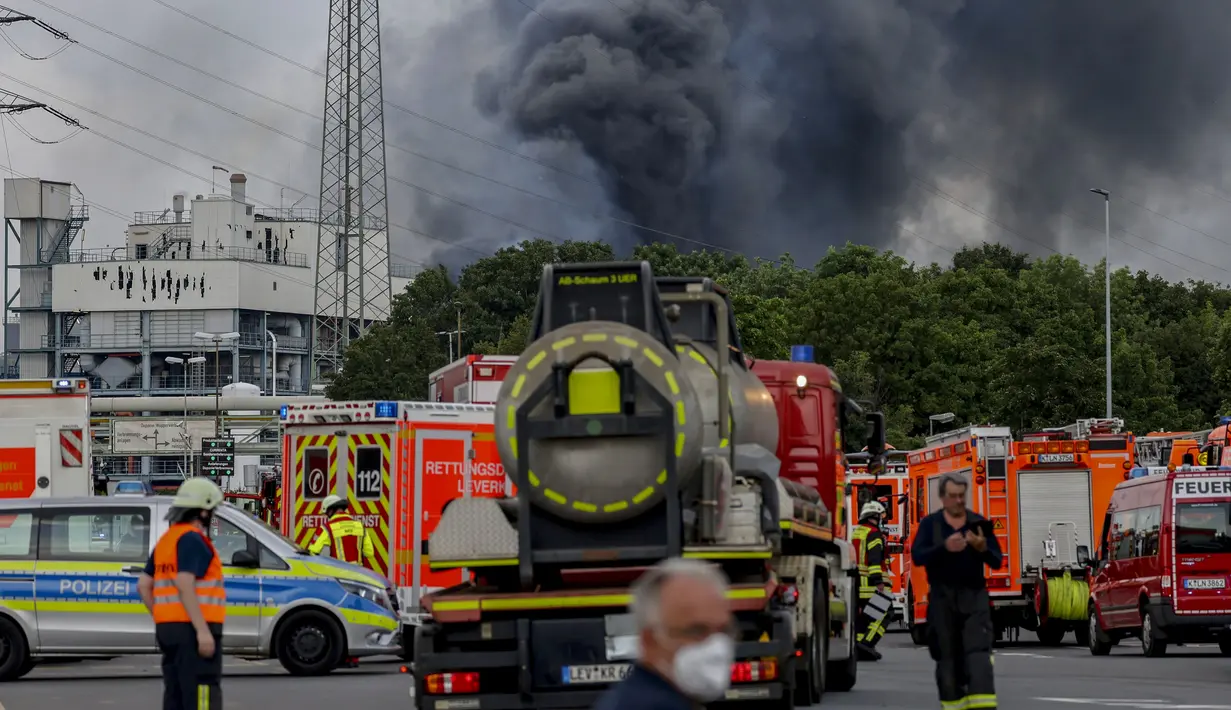 Kendaraan darurat pemadam kebakaran, layanan penyelamatan dan polisi terlihat tidak jauh dari akses jalan ke Chempark di mana asap membubung di Leverkusen, Jerman (21/7/2021). Kepolisian masih menyelidiki kasus ledakan dan belum diketahui penyebab terjadinya ledakan itu. (AP Photo/Oliver Berg)