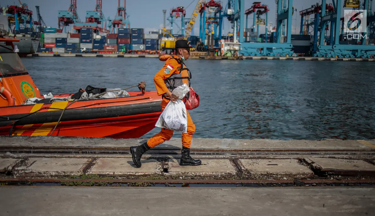 Petugas Basarnas membawa serpihan pesawat Lion Air JT 610 yang jatuh di Posko Evakuasi, Tanjung Priok, Jakarta, Senin (29/10). Lion Air JT 610 hilang kontak usai lepas landas dari Bandara Soetta saat menuju Pangkalpinang. (Liputan6.com/Faizal Fanani)