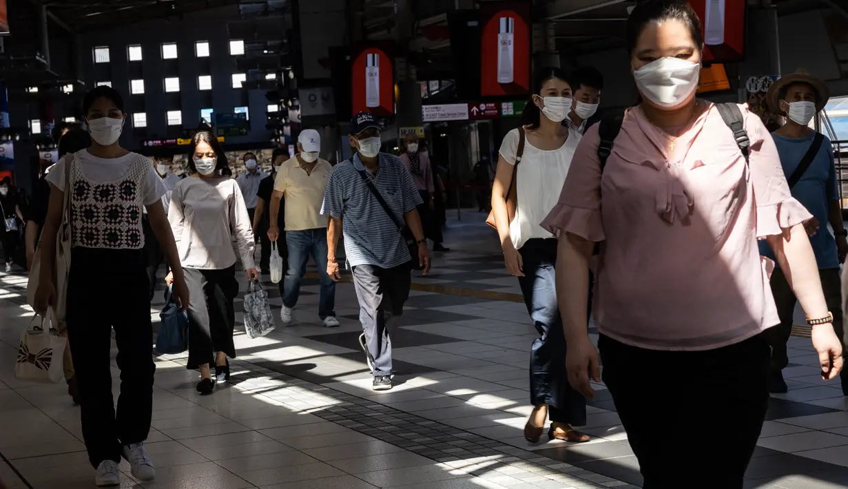 Komuter memakai masker di stasiun kereta api di Tokyo saat keadaan darurat virus corona tetap berlaku di kota itu pada Selasa (10/8/2021).  Pemerintah Metropolitan Tokyo mengonfirmasi 2.884 kasus baru covid-19 pada Senin, 9 Agustus 2021. (Yuki IWAMURA / AFP)