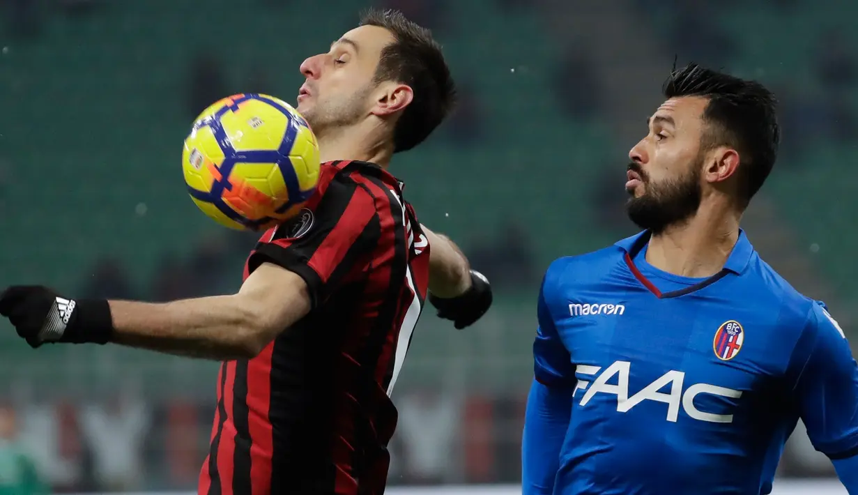 Pemain AC Milan, Nikola Kalinic berebut bola dengan pemain Bologna, Giancarlo Gonzalez dalam lanjutan pekan ke-16 Liga Italia di Stadion San Siro, Senin (11/12). AC Milan buka puasa kemenangan setelah mengalahkan Bologna 2-1. (AP Photo/Luca Bruno)