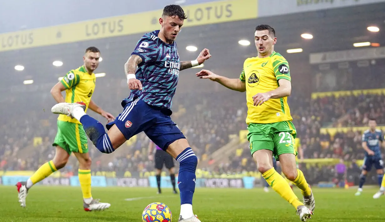 Pemain Arsenal Ben White dan pemain Norwich City Kenny McLean (kanan) berebut bola pada pertandingan sepak bola Liga Inggris di Stadion Carrow, Norwich, Inggris, Minggu (26/12/2021). Arsenal menang 5-0. (Joe Giddens/PA via AP)
