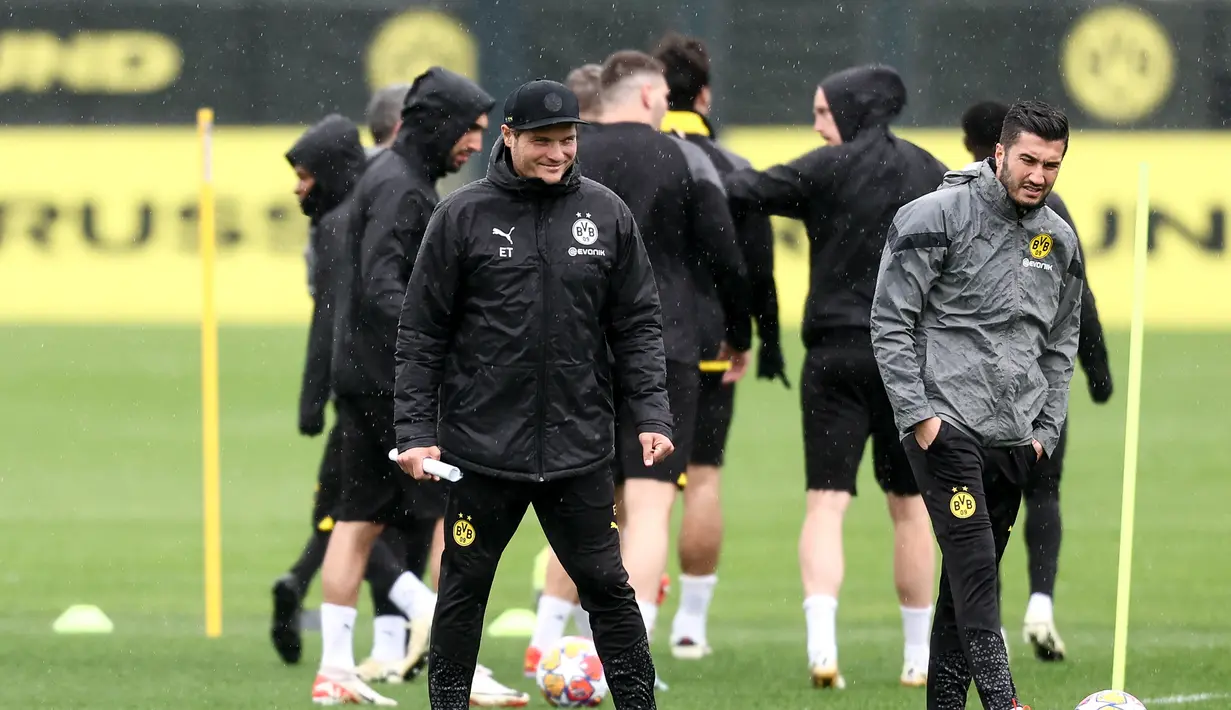 Pelatih Borussia Dortmund Edin Terzic dan asisten pelatih Nuri Sahin menghadiri sesi latihan menjelang leg kedua perempat final Liga Champions di tempat latihan klub di Dortmund, Jerman barat, Senin (15/4/2024). (LEON KUEGELER / AFP)