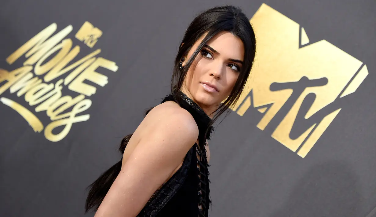 Model Kendall Jenner ketika menghadiri acara MTV Movie Awards 2016 di Burbank, California, Sabtu (9/4). Adik tiri Kim Kardashian itu mencuri perhatian dalam balutan dress hitam menerawang yang seksi. (Frazer HARRISON/GETTY IMAGES NORTH AMERICA/AFP)