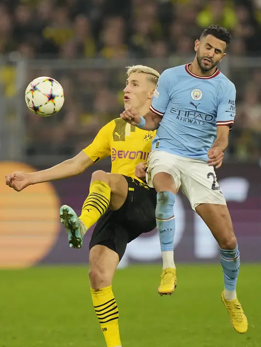 Penyerang Manchester City Riyad Mahrez berebut bola dengan bek Borussia Dortmund Nico Schlotterbeck pada matchday 5 Grup G Liga Champions 2022/2023 di Signal Iduna Park, Rabu (26/10/2022) dini hari WIB. The Citizens -julukan Man City- membawa pulang satu angka setelah ditahan 0-0. (AP Photo/Martin Meissner)