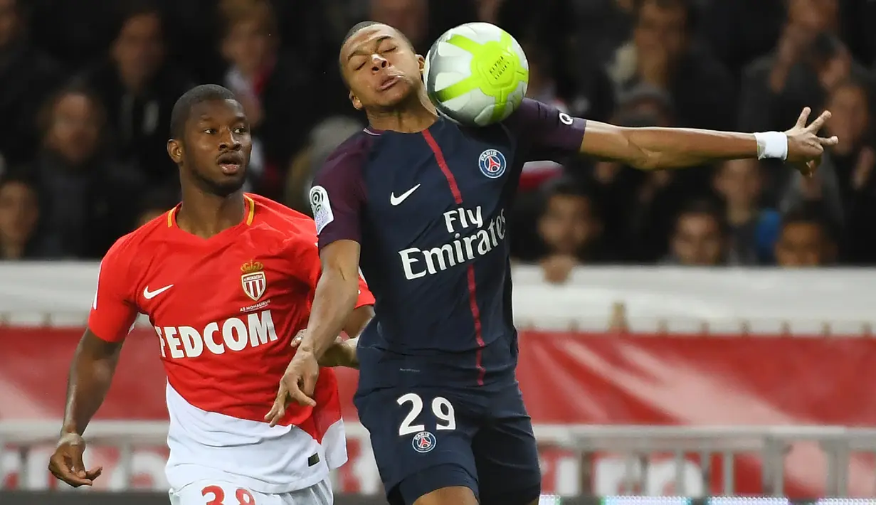 Pemain PSG, Kylian Mbappe (kanan) menguasai bola saat melewati adangan pemain AS Monaco, Almamy Toure (kiri)  pada lanjutan Ligue 1 di Louis II stadium, Monaco, (26/11/2017). PSG menang 2-1. (AFP/Anne-Christine Poujoulat)