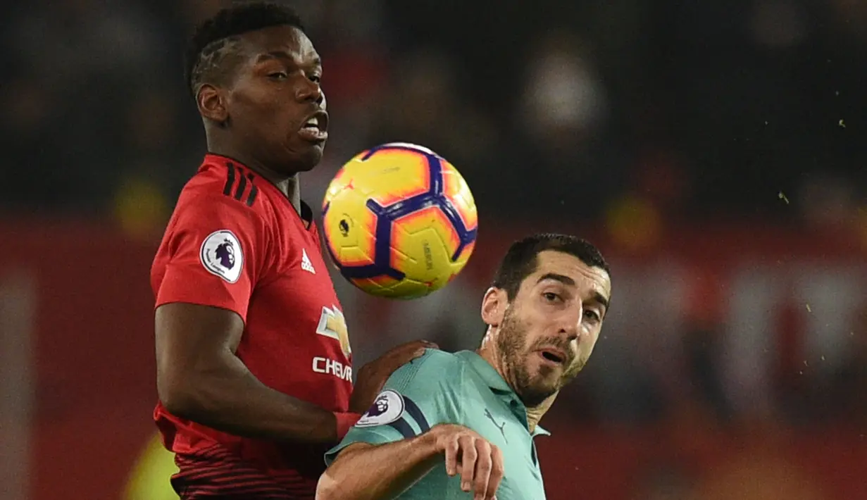 Gelandang Manchester United, Paul Pogba berebut bola dengan gelandang Arsenal, Henrikh Mkhitaryan selama pertandingan lanjutan Liga Inggris di stadion Old Trafford (5/12). MU bermain imbang 2-2 atas Arsenal. (AFP Photo/Oli Scarff)
