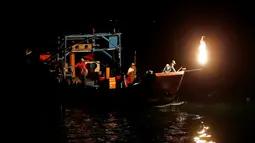 Nelayan Taiwan saat mencari ikan menggunakan api sebagai umpan di perairan New Taipei City, Taiwan, (19/6). Kini Metode tradisional ini hanya digunakan segelintir nelayan dan tersisa tiga kapal saja setiap malam. (REUTERS/Tyrone Siu)