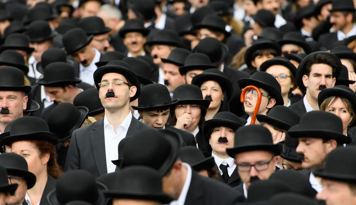 Sejumlah penggemar menggelar pertemuan dengan mengenakan kostum Charlie Chaplin di Corsier sur Vevey, Minggu (16/4). Pertemuan yang dihadiri 662 orang itu memperingati hari jadi pertama Museum Charlie Chaplin di Swiss. (Laurent Gillieron/Keystone via AP)