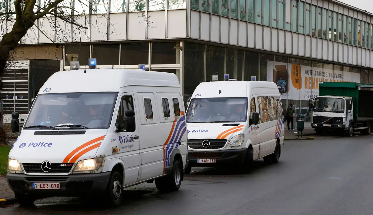 Polisi berjaga-jaga dekat dearler mobil setelah ditangkapnya buronan penyerangan Paris Mohamed Abrini di Anderlecht, Belgia, (8/4). Mohamed Abrini tak berkutik ketika dibekuk pasukan khusus Belgia. (REUTERS/Yves Herman)