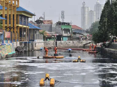 Petugas PPSU membersihkan sampah saat pengoperasian Nano Bubble dan Aerator di Kali Sentiong atau Kali Item, Jakarta, Kamis (2/8). Pemprov DKI Jakarta terus berupaya membersihkan dan mengurangi bau tak sedap di Kali Item. (Merdeka.com/Iqbal S. Nugroho)