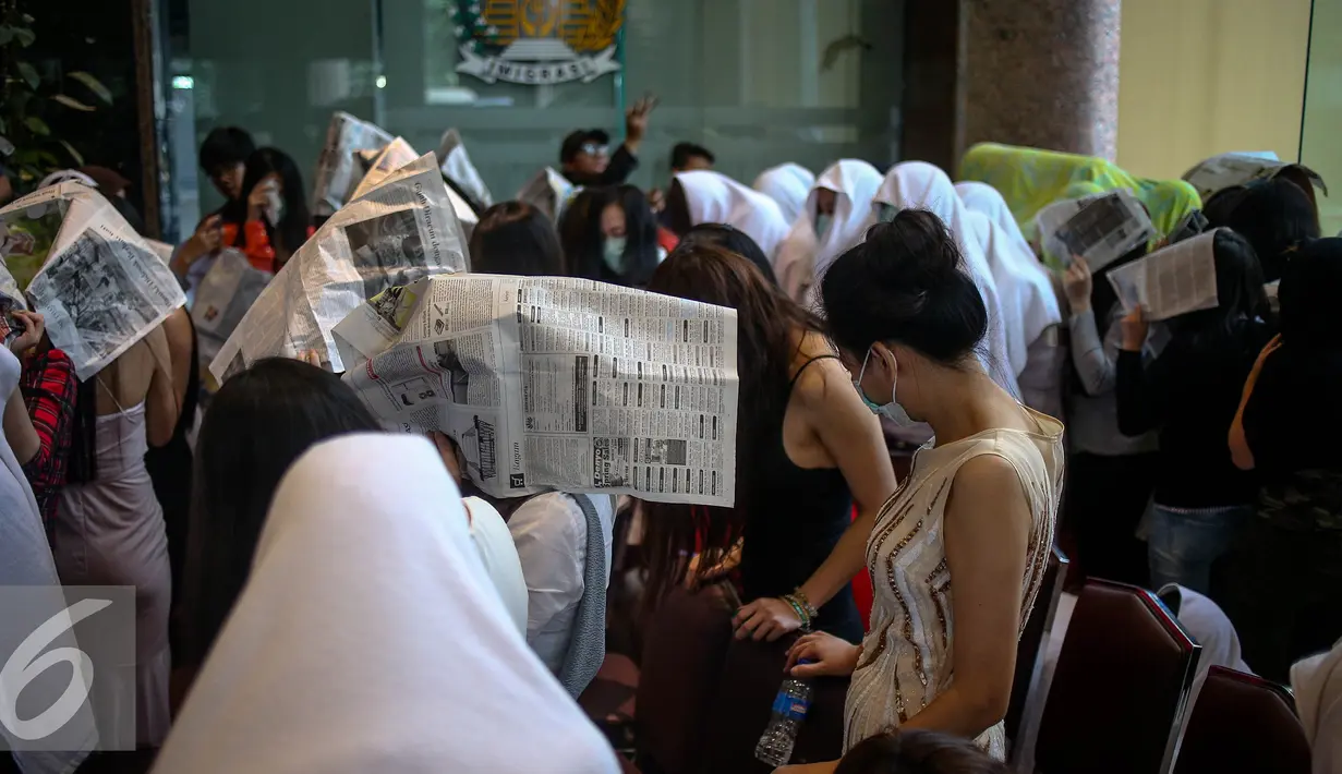 Sejumlah Warga Negara Asing menutupi wajahnya saat diamankan petugas di Direktorat Jenderal Imigrasi, Jakarta, Minggu (1/1). Direktorat Jenderal Imigrasi menciduk 76 wanita kewarganegaraan China di sejumlah kelab malam. (Liputan6.com/Faizal Fanani)