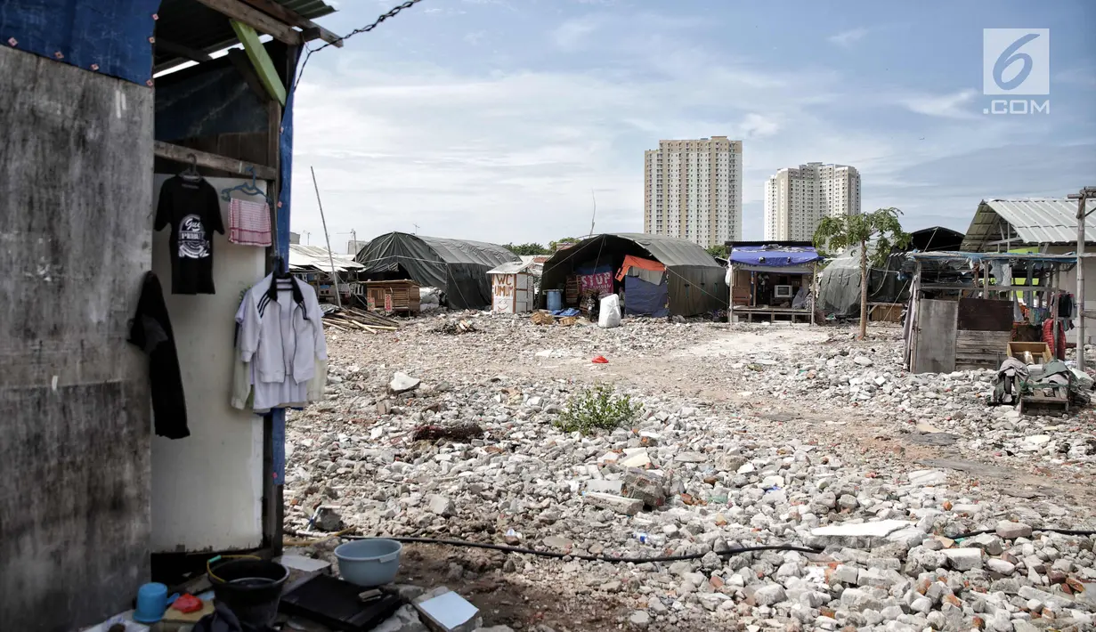 Pemandangan bangunan semi permanen di Kampung Akuarium dengan latar belakang apartemen di Jakarta, Rabu (6/11). Sandi menjelaskan, rumah berlapis akan dibangun secara vertikal, tetapi tidak terlalu tinggi. (Liputan6.com/Faizal Fanani)