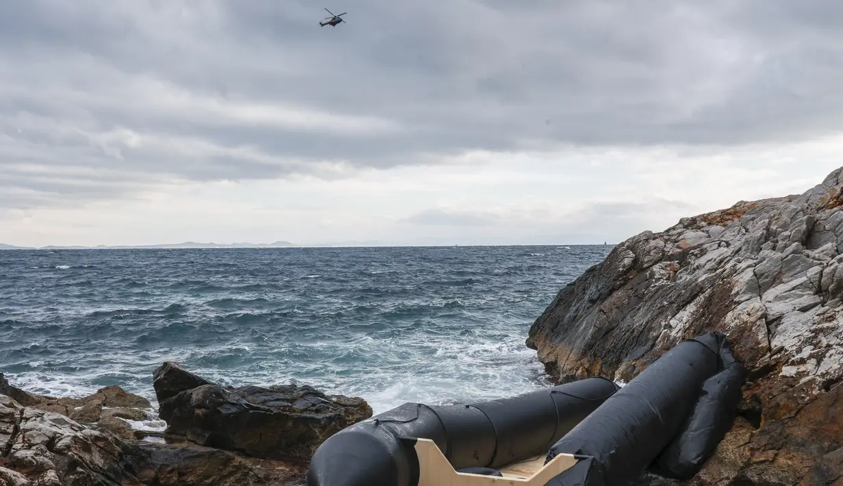 <p>Sebuah helikopter penyelamat terbang di atas laut dekat tempat perahu karet, yang diyakini digunakan oleh para migran, hancur di garis pantai berbatu, di Thermi di pulau Lesbos, Yunani, pada 7 Februari 2023. Dua wanita dan satu pria yang tenggelam diyakini sebagai bagian dari kelompok 41 orang yang perahunya tenggelam setelah menabrak karang di dekat pulau Lesbos, kata seorang juru bicara penjaga pantai kepada AFP. (Manolis Lagoutaris / AFP)</p>