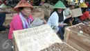 Petani wanita ikut dalam aksi sejumlah petani yang mengubur diri di halaman Monas, Jakarta, Senin (1/5). Aksi kubur diri dilakukan untuk mendapat perhatian pemerintah terkait konflik agraria di Telukjambe, Karawang. (Liputan6.com/Yoppy Renato)