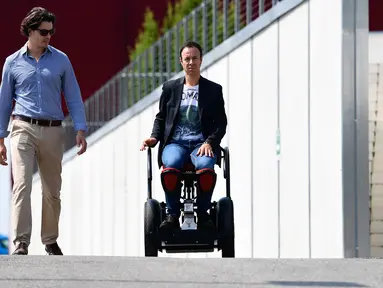Pencipta MarioWay, Mario Vigentini (kanan) menjajal temuannya di Taman Ilmiah dan Teknologi "Kilometro Rosso", Italia, 19 Juli 2017. MarioWay merupakan kursi roda listrik berteknologi canggih yang dapat dijalankan tanpa kendali tangan  (MIGUEL MEDINA/AFP)
