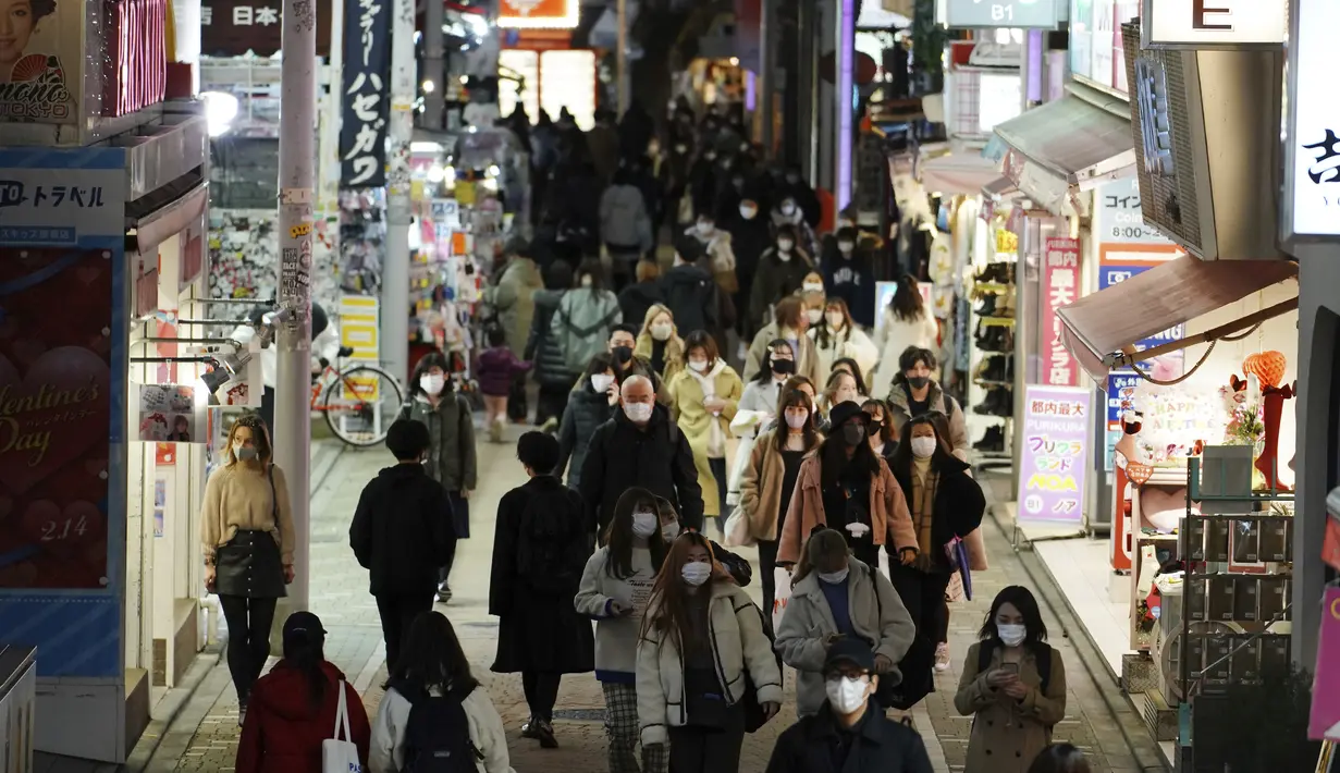 Orang-orang memakai masker untuk mencegah penyebaran virus corona berjalan di pusat perbelanjaan di Tokyo (9/2/2021). Jepang telah memberlakukan UU yang memungkinkan pejabat untuk menegakkan tindakan virus corona dengan menghukum pelanggar perintah wajib dengan denda. (AP Photo/Eugene Hoshiko)