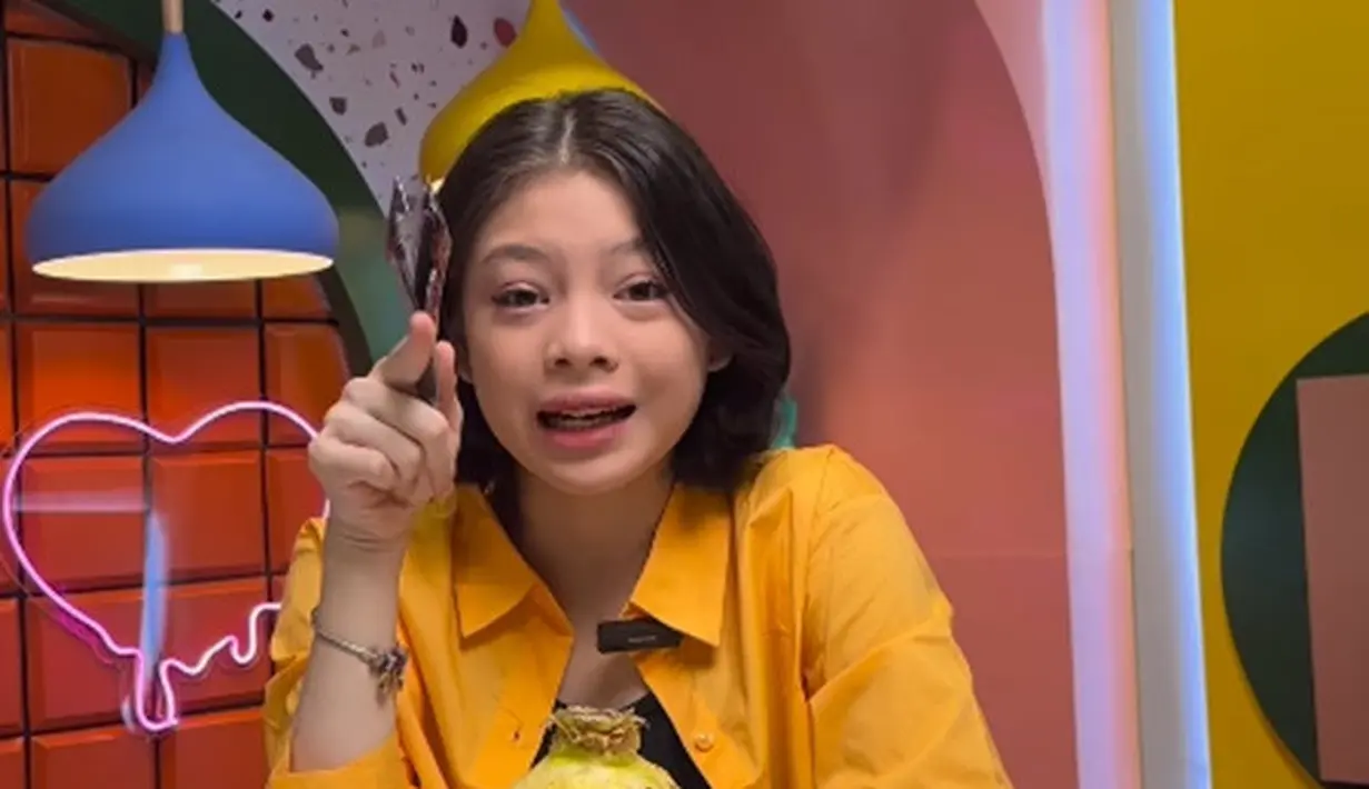 Nada juga terlihat cantik mengenakan outfit berwarna terang. Seperti di video ini, Nada memadukan tank top hitam dengan kemeja oranye yang dijadikannya sebagai outer. [Foto: Instagram/sabrinachairunnisa_]