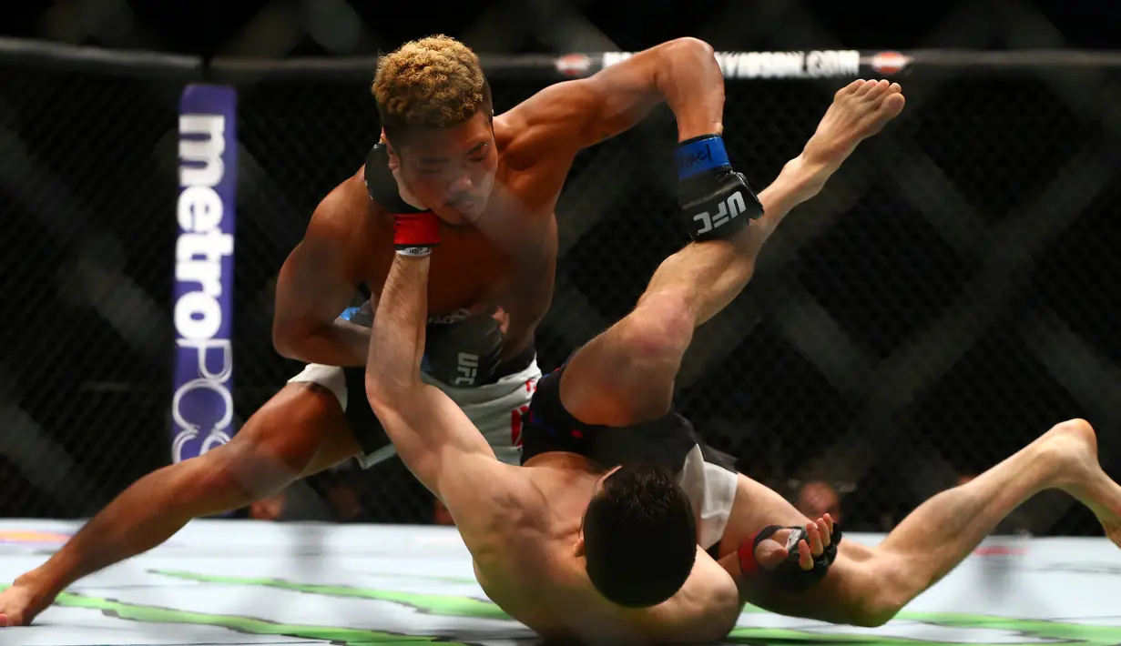 Pemain UFC  Teroto Ishihara melayangkan pukulannya kepada Julian Erosa pada pertandingan UFC 196 di MGM Grand Garden Arena, Las Vegas, (5/3). UFC adalah singkatan dari (ULTIMATE FIGHTING CHAMPIONSHIP). (Rebilas-USA TODAY Sports)