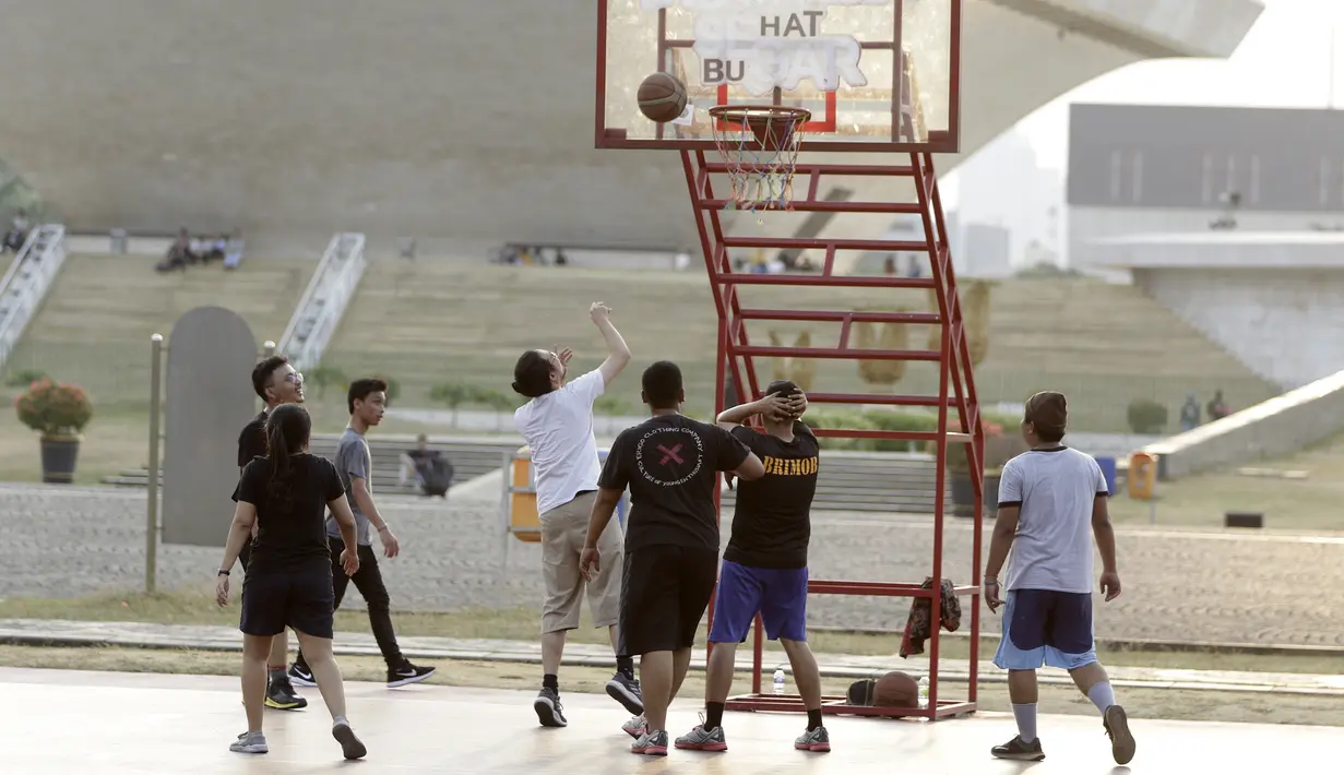 Sejumlah warga bermain basket di kawasan Monas, Jakarta, Jumat (11/10). Kawasan Monas menjadi pilihan warga Jakarta dan pekerja ibu kota untuk berolahraga sore. (Bola.com/Yoppy Renato)