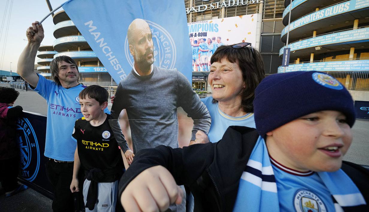 Sejumlah suporter Manchester City merayakan gelar juara Liga Inggris di depan Stadion Etihad, Sabtu (20/5/2023). City memastikan gelar juara setelah Arsenal dikalahkan Nottingham Forest dengan skor 0-1 pada lanjutan Liga Inggris 2022/2023 hari Minggu (21/05/2023). (AP Photo/Jon Super)