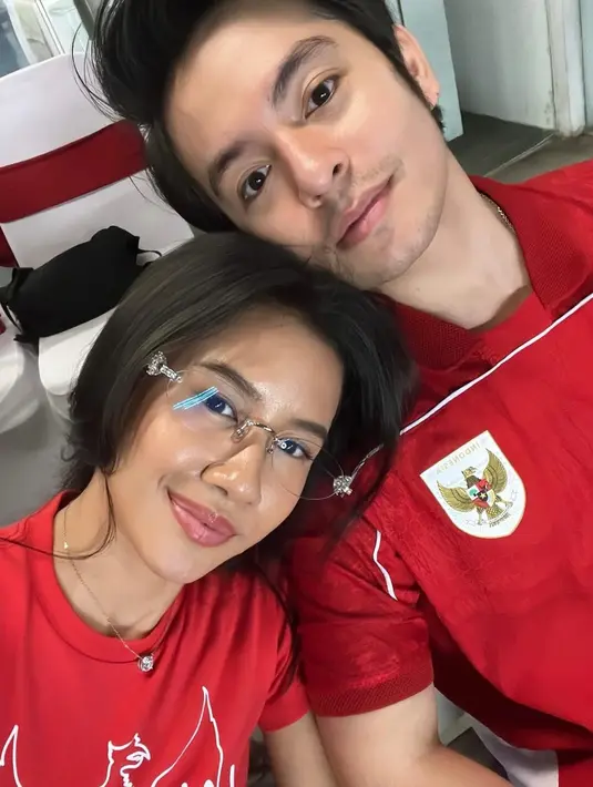 Pasutri baru Angga Yunanda dan Shenina tampil kembaran dengan kaus berwarna merah dengan logo Garuda. [@angga].