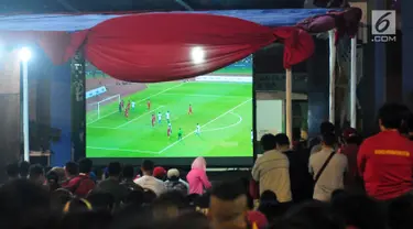 Sejumlah warga menonton pertandingan sepak bola Indonesia melawan Malaysia dalam pertandingan Sea Games 2017 di Area Kementerian Pemuda dan Olahraga, Jakarta, Sabtu (27/8). (Liputan6.com/Helmi Afandi)