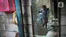 Refleksi pada cermin memperlihatkan seorang anak membawa galon saat banjir rob di Muara Angke, Jakarta, Jumat (25/11/2022). Badan Penanggulangan Bencana Daerah (BPBD) DKI Jakarta mengimbau agar warga di pesisir Jakarta mengantisipasi banjir pesisir atau rob selama 22-28 November 2022. (Liputan6.com/Faizal Fanani)