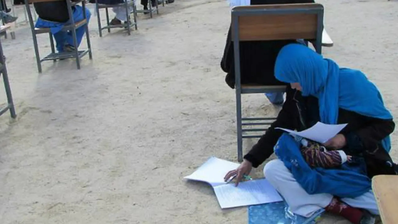 Foto wanita menggendong bayi saat ujian di Afganistan. (AFP)
