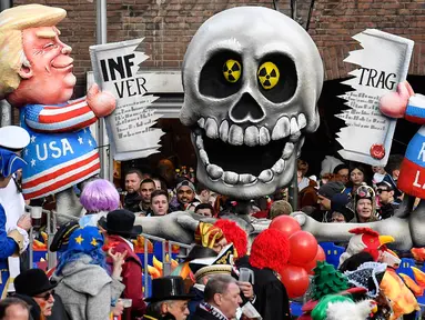 Karakter yang menggambarkan Presiden AS Donald Trump dan Presiden Rusia Vladimir Putin sedang berebut perjanjian INF memeriahkan Karnaval Rose Monday di Duesseldorf, Jerman, Senin (4/3). (AP Photo/Martin Meissner)
