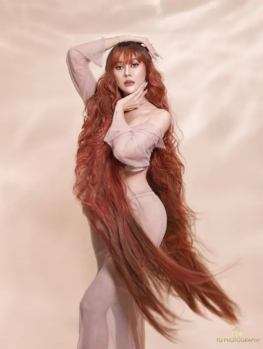 Saking panjangnya, Aura Kasih ramai dipuji penggemarnya bak tokoh kartun Rapunzel. Terlihat bahkan pemain series film "Gelas Kaca" ini rambutnya hampir menyentuh mata kaki. Lewat posenya yang khas, Aura Kasih disebur Rapunzelnya Indonesia. (Liputan6.com/IG/@aurakasih)