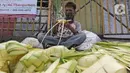 Pedagang menyelesaikan pembuatan kulit ketupat di kawasan Cibubur, Jakarta, Rabu (30/7/2020). Pedagang musiman menjelang Idul Adha tersebut menjual kulit ketupat dengan harga Rp 10 ribu, sedangkan ketupat yang siap untuk dihidangkan seharga Rp 30 ribu. (Liputan6.com/Herman Zakharia)
