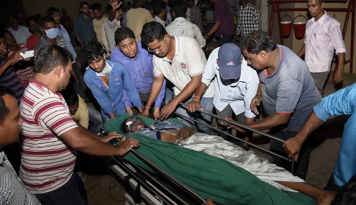 Petugas memindahkan korban ke rumah sakit lain saat kebakaran besar melanda rumah sakit SUM Bhubaneshwar di Odisha, India Timur, Senin (17/10). Sebanyak 120 petugas pemadam dikerahkan dan butuh waktu hampir dua jam untuk mengendalikan si jago merah. (AFP)