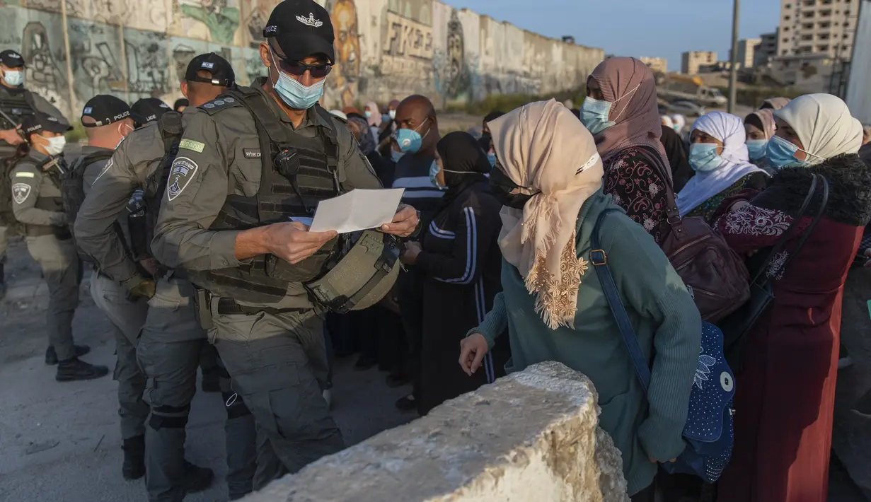 Wanita Palestina menunggu untuk menyeberangi pos pemeriksaan Qalandia antara kota Ramallah Tepi Barat dan Yerusalem, untuk menghadiri sholat Jumat pertama di masjid al-Aqsa, selama bulan suci Ramadhan, Jumat (16/4/2021).  (AP Photo/Nasser Nasser)