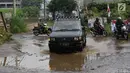 Kendaraan menghindari kubangan pada jalan yang rusak di Jalan Pertamina, Kemiri Muka, Depok, Jawa Barat, Selasa (5/3). Kondisi tersebut mengganggu aktivitas warga serta pengguna jalan. (Liputan6.com/Immanuel Antonius)