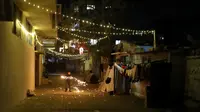 Seorang anak bermain kembang api di depan rumah keluarganya saat merayaka bulan suci Ramadhan di sepanjang gang di Kota Gaza, Palestina, Selasa (20/4/2021). Umat muslim dunia melangsungkan puasa selama satu bulan penuh pada bulan suci Ramadhan. (AP Photo/Adel Hana)