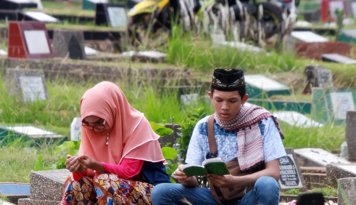 Warga berdoa saat berziarah di TPU Karet Pasar Baru Barat, Jakarta, Sabtu (16/6). Ziarah kubur atau "nyekar" pada hari raya lebaran merupakan salah satu tradisi umat muslim untuk mendoakan sanak keluarga yang meninggal dunia. (Liputan6.com/Arya Manggala)