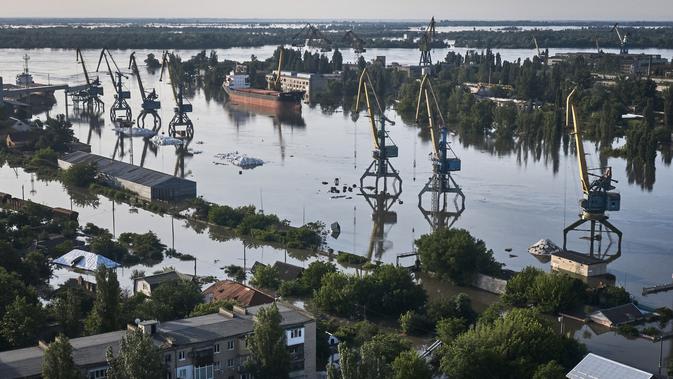 Dini hari, sebelum banjir datang, banyak warga yang mencoba bertahan. (AP Photo/Libkos)