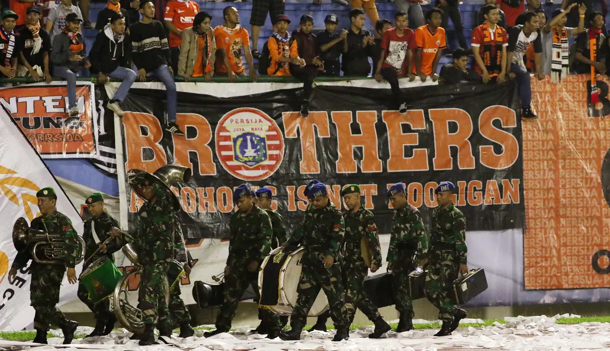 Suporter PS TNI berjalan melintas dekat suporter Persija pada laga Piala Jenderal Sudirman di Stadion Manahan, Solo, Sabtu (12/11/2015). (Bola.com/Nicklas Hanoatubun)
